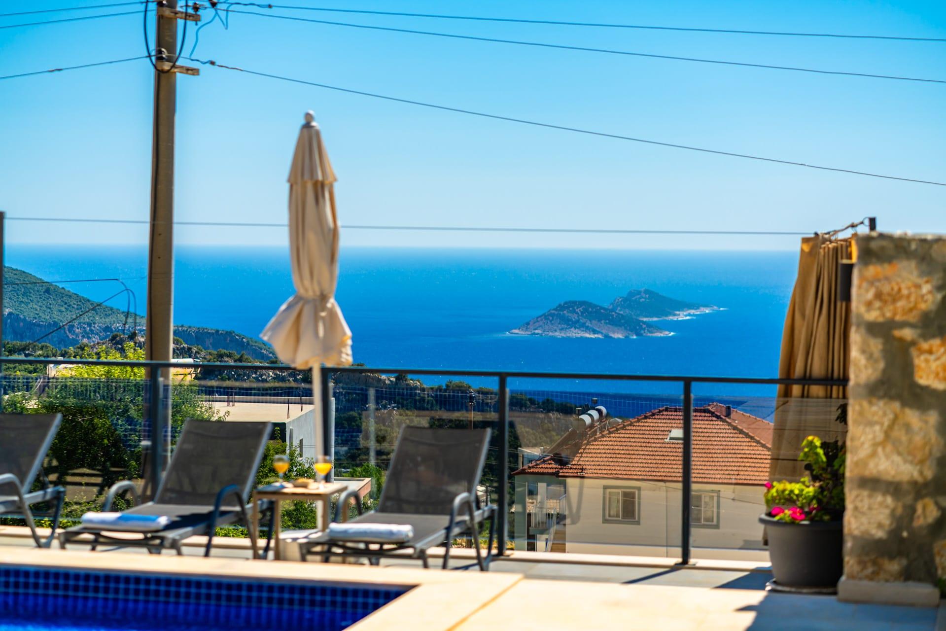 Terasta şezlonglar ve deniz manzarası