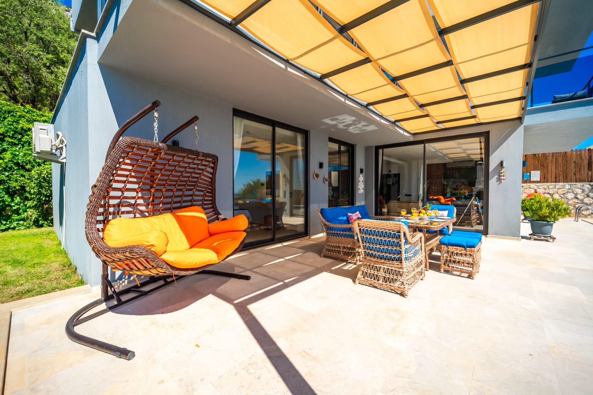 Pergola altında salıncak koltuk ve yemek alanı