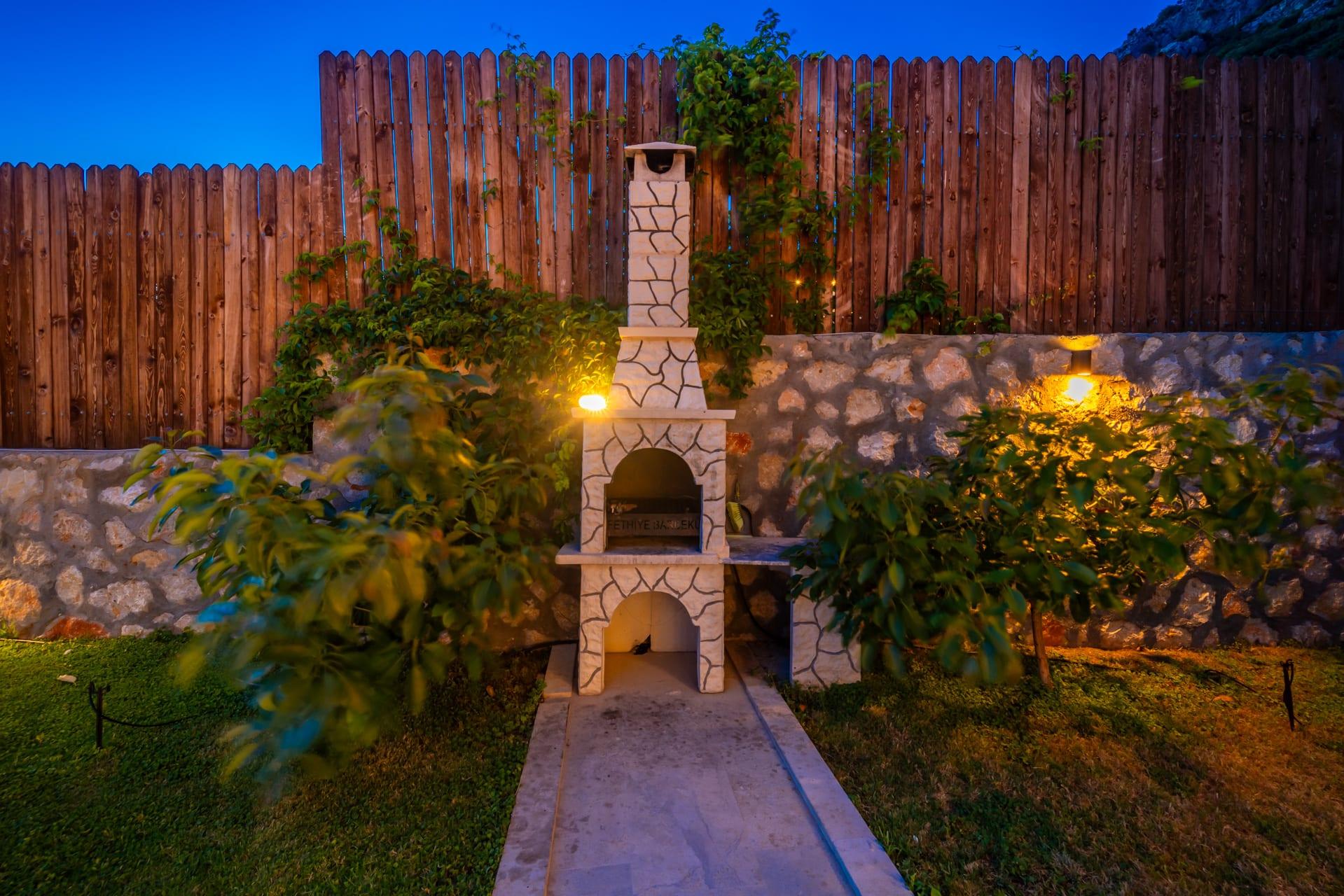 Gece aydınlatmasıyla taş barbekü alanı